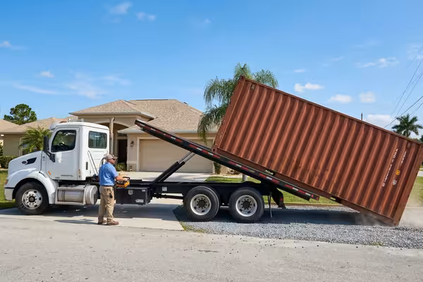 Tilt-bed trailer delivering a shipping container